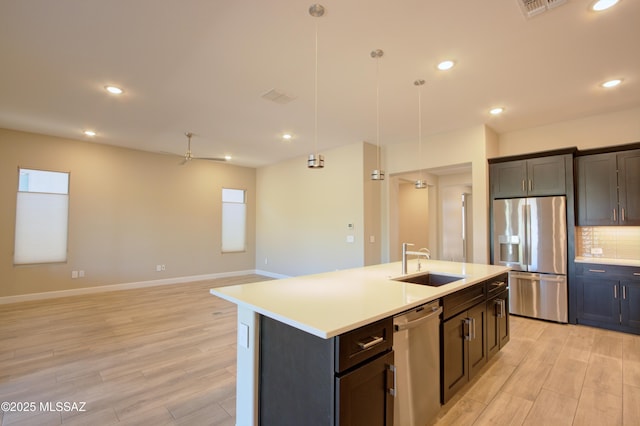 62908 E Thunder Rock Dr, Tucson, AZ 85739 - kitchen with a sink, stainless steel appliances, light countertops, and light wood-type flooring