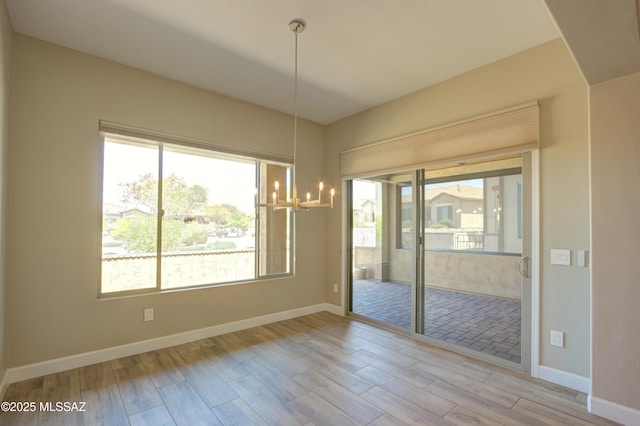 62908 E Thunder Rock Dr, Tucson, AZ 85739 - unfurnished dining area featuring an inviting chandelier, wood finished floors, and baseboards