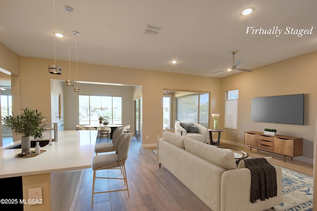62908 E Thunder Rock Dr, Tucson, AZ 85739 - living area featuring visible vents, recessed lighting, light wood-style flooring, a wealth of natural light, and a ceiling fan
