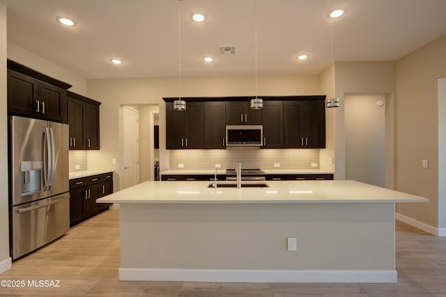 62908 E Thunder Rock Dr, Tucson, AZ 85739 - kitchen featuring visible vents, appliances with stainless steel finishes, a sink, and decorative backsplash