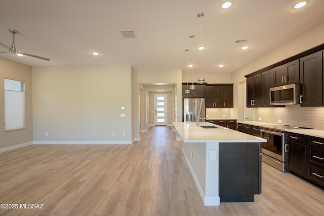 62908 E Thunder Rock Dr, Tucson, AZ 85739 - kitchen featuring a sink, stainless steel appliances, backsplash, light countertops, and baseboards
