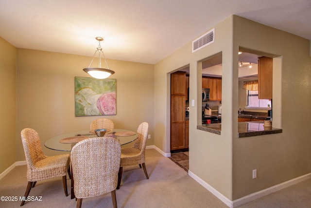 dining space with light colored carpet, baseboards, and visible vents