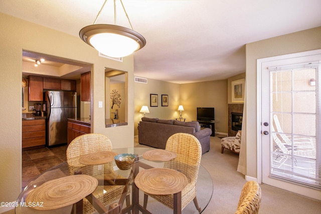 dining area featuring carpet flooring, visible vents, and a healthy amount of sunlight
