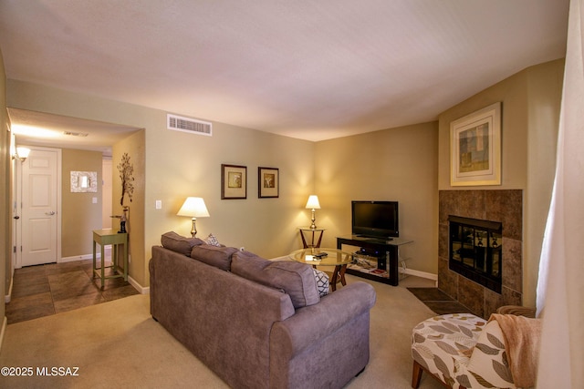 living area with carpet floors, baseboards, visible vents, and a fireplace