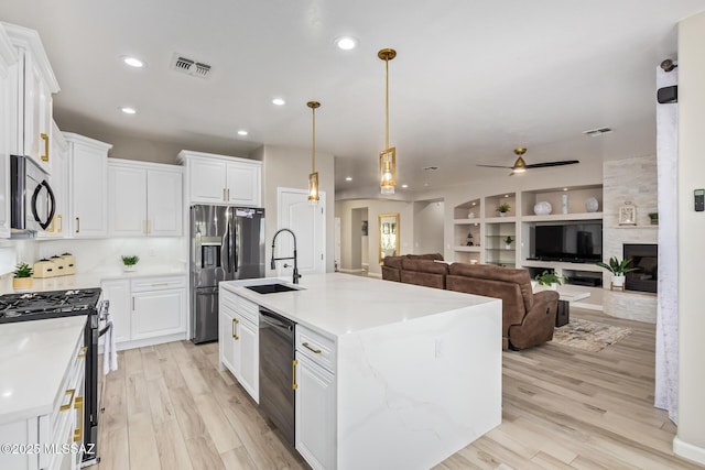 kitchen featuring a sink, appliances with stainless steel finishes, white cabinetry, and visible vents