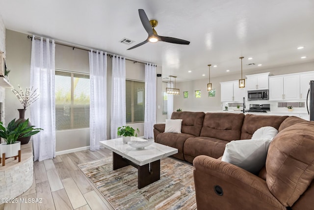 living area with recessed lighting, ceiling fan, visible vents, and baseboards