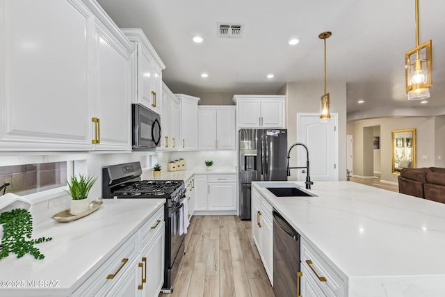kitchen with recessed lighting, visible vents, a sink, and black appliances