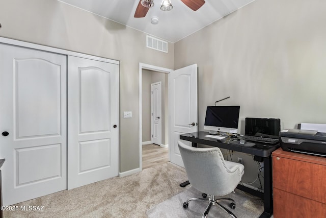 office featuring visible vents, a ceiling fan, baseboards, and light colored carpet