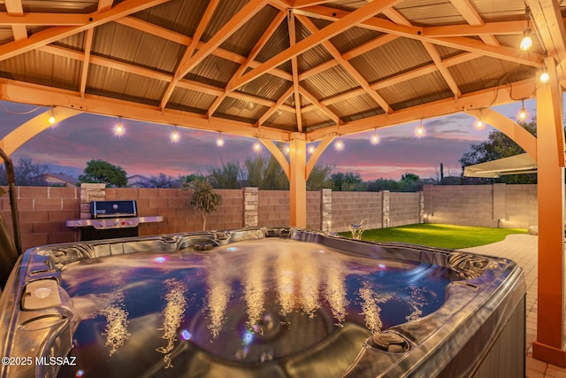 exterior space featuring a hot tub, a gazebo, and a fenced backyard