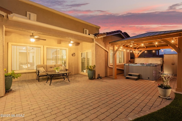 view of patio / terrace with a hot tub, a gazebo, and an outdoor living space