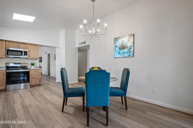 9453 E Pena Dr, Tucson, AZ 85730 - dining space with an inviting chandelier, light wood finished floors, high vaulted ceiling, baseboards, and visible vents
