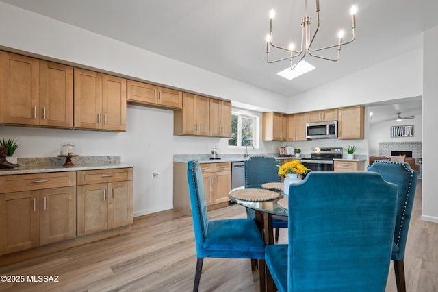 9453 E Pena Dr, Tucson, AZ 85730 - kitchen with stainless steel appliances, an inviting chandelier, vaulted ceiling, and light wood-style floors