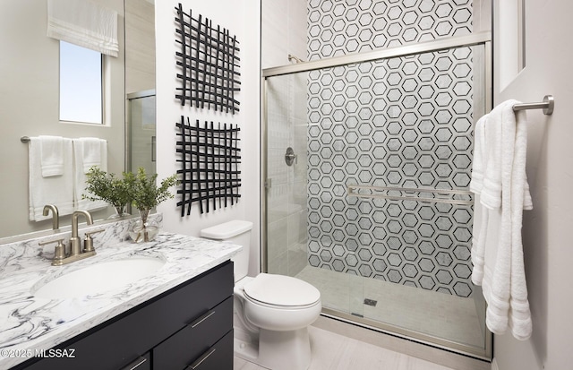 full bath with a stall shower, vanity, and toilet