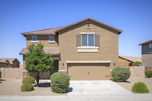 traditional home featuring an attached garage, stucco siding, and fence