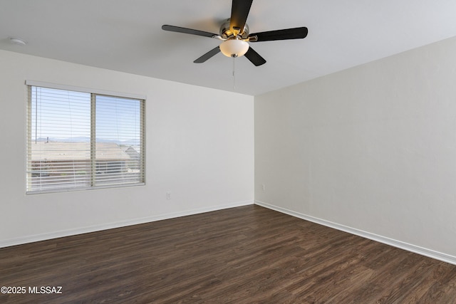 empty room featuring dark wood-style flooring, ceiling fan, baseboards, and a smoke detector