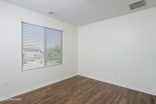 empty room with dark wood-type flooring and baseboards