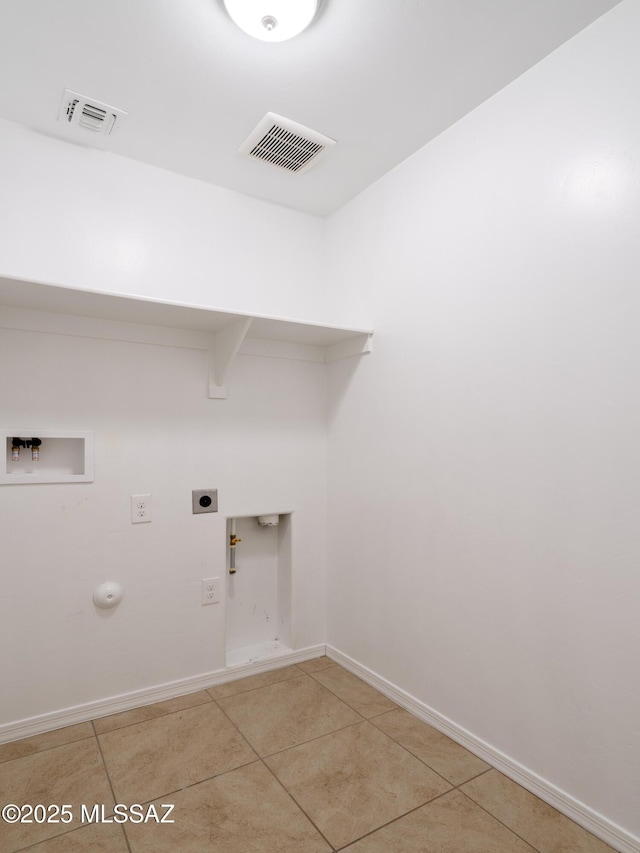 washroom featuring hookup for a gas dryer, hookup for a washing machine, light tile patterned floors, and baseboards