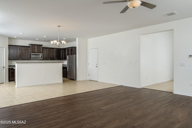 unfurnished living room with a chandelier, light wood-type flooring, ceiling fan, recessed lighting, and baseboards