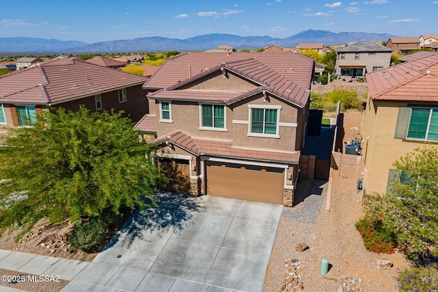 traditional-style house featuring an attached garage, stucco siding, a tile roof, and a residential view