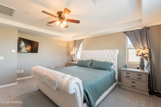bedroom featuring baseboards, a tray ceiling, visible vents, and carpet floors