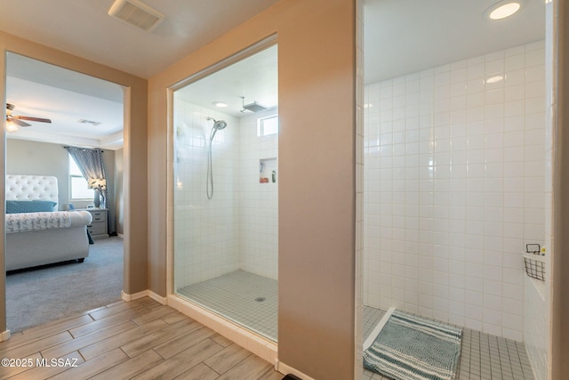 full bathroom with a ceiling fan, ensuite bathroom, wood tiled floor, and a tile shower