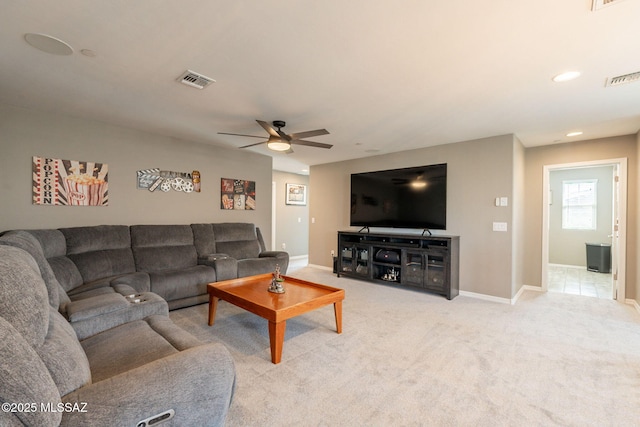 living area with light colored carpet, visible vents, baseboards, and ceiling fan