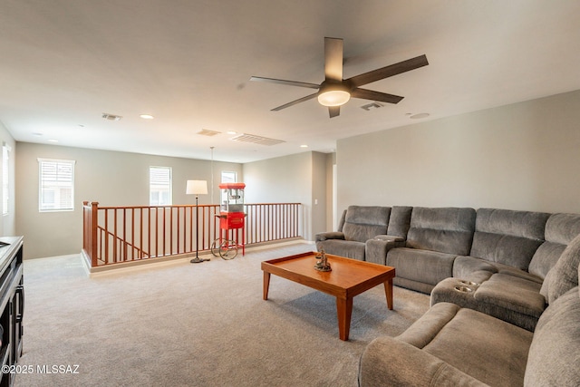 living room with light colored carpet, visible vents, and ceiling fan