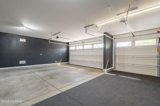 garage featuring baseboards, visible vents, and a garage door opener