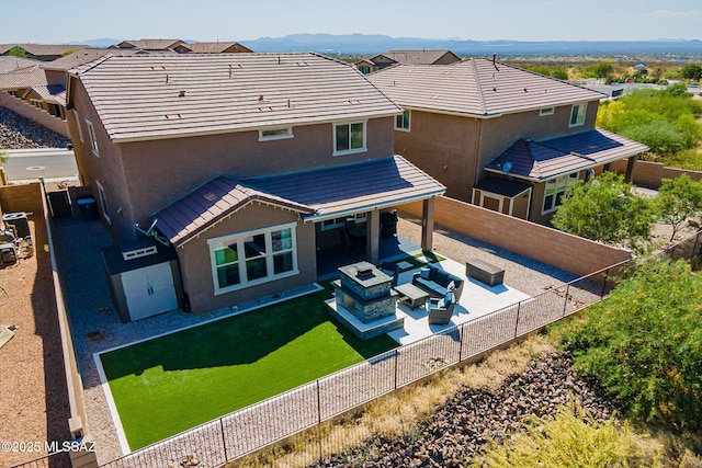 back of property featuring an outdoor living space with a fire pit, stucco siding, a patio area, and a fenced backyard