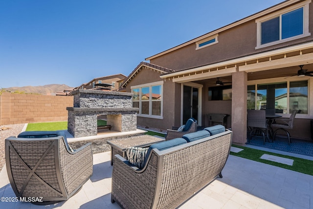 view of patio / terrace featuring ceiling fan, fence, an outdoor living space with a fireplace, and outdoor dining space