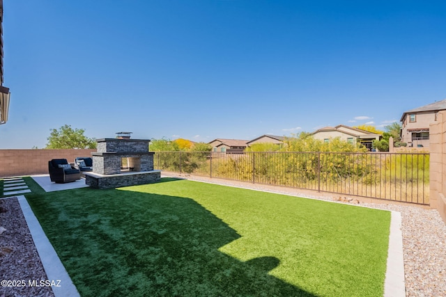 view of yard featuring a patio area, a residential view, an outdoor living space with a fireplace, and a fenced backyard