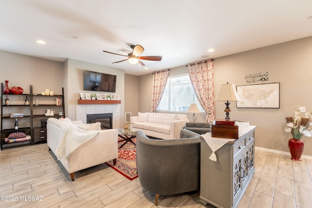 living room with wood finish floors, a ceiling fan, recessed lighting, and a tile fireplace