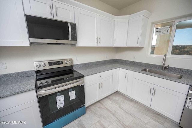 kitchen with a sink, white cabinets, and stainless steel appliances