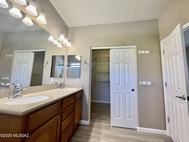 bathroom with baseboards, a sink, and wood finished floors
