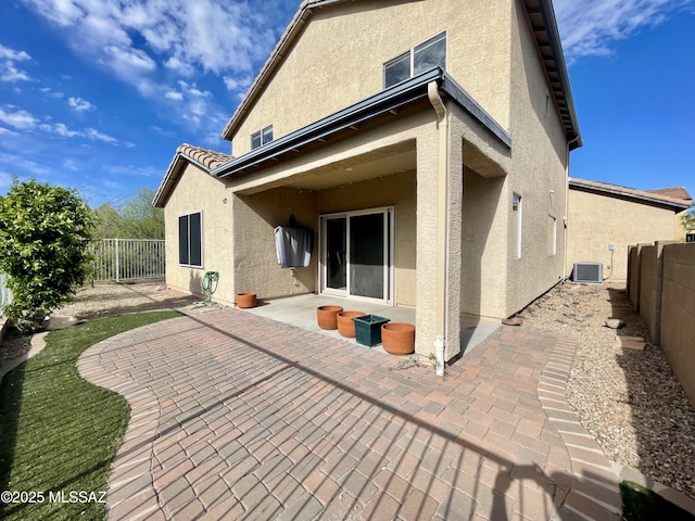 back of property with a patio area, stucco siding, and a fenced backyard