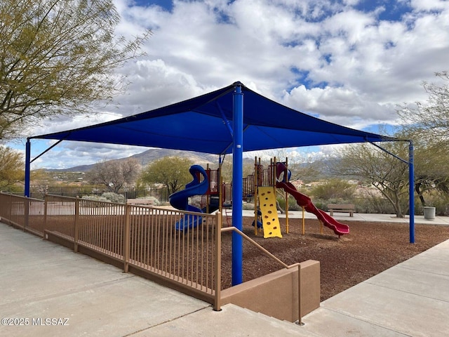 community jungle gym with fence and a mountain view