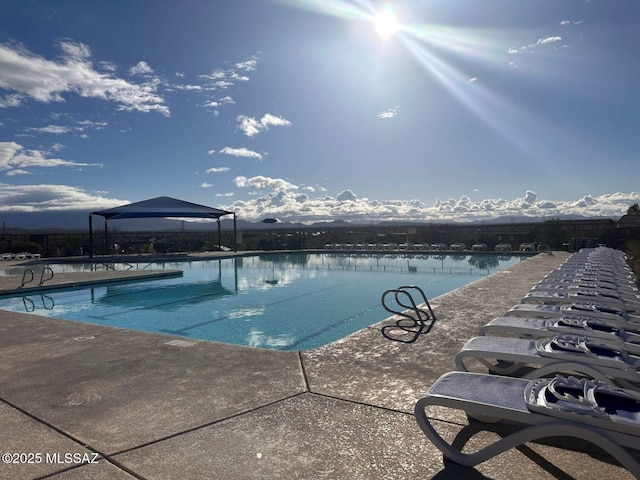 community pool with a gazebo and a patio area