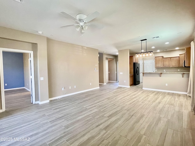 unfurnished living room featuring ceiling fan, light wood-style flooring, baseboards, and visible vents