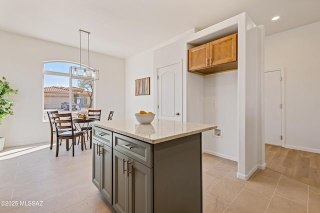 9896 E Wind Dancer Dr, Tucson, AZ 85748 - kitchen featuring light stone countertops, baseboards, a center island, recessed lighting, and hanging light fixtures