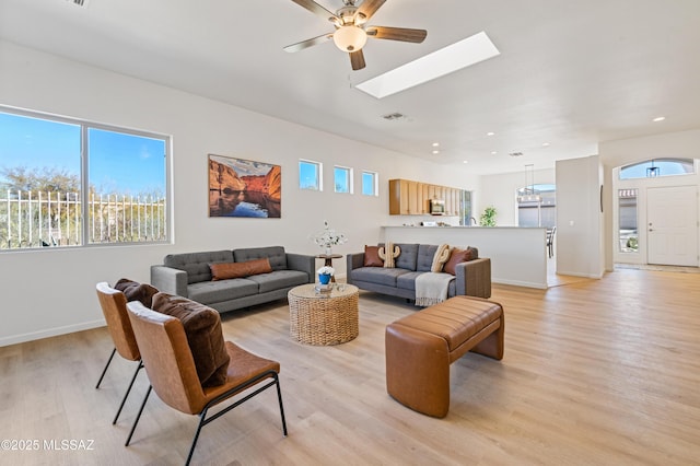 9896 E Wind Dancer Dr, Tucson, AZ 85748 - living room featuring a ceiling fan, visible vents, a skylight, baseboards, and light wood finished floors