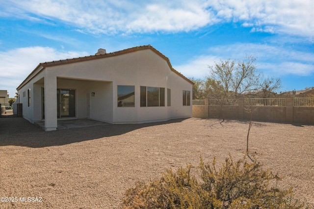 9896 E Wind Dancer Dr, Tucson, AZ 85748 - back of house featuring a tiled roof, a chimney, fence, a patio, and stucco siding