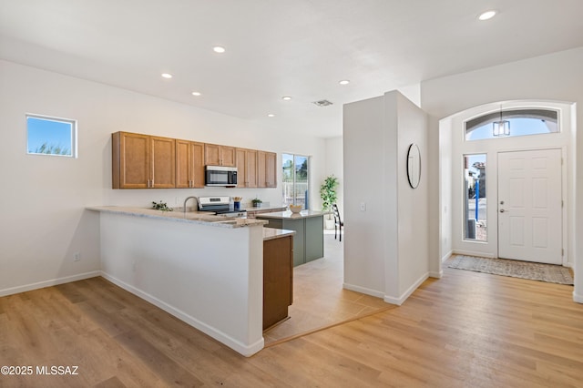 9896 E Wind Dancer Dr, Tucson, AZ 85748 - kitchen featuring recessed lighting, light wood-style flooring, a peninsula, and stainless steel appliances