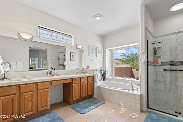 full bathroom with a sink, double vanity, a shower stall, and a garden tub