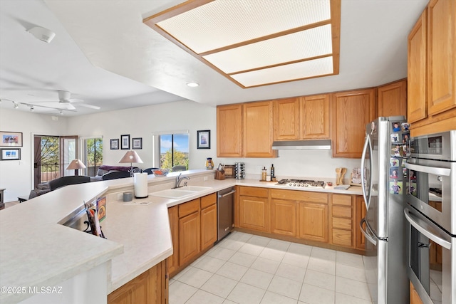 kitchen featuring a sink, light countertops, stainless steel appliances, open floor plan, and light tile patterned floors