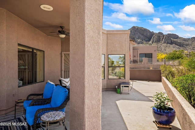 view of patio featuring a ceiling fan and a mountain view
