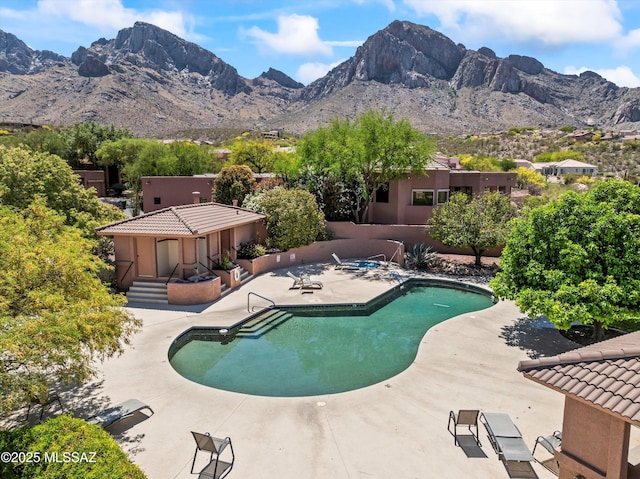 pool featuring a patio area and a mountain view