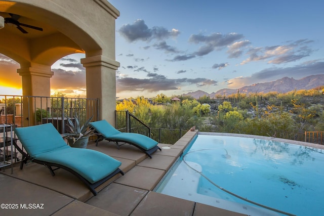 4519 N Camino Kino, Tucson, AZ 85718 - pool at dusk with ceiling fan and a mountain view
