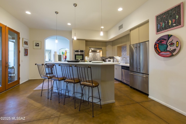 4519 N Camino Kino, Tucson, AZ 85718 - kitchen with stainless steel appliances, concrete floors, backsplash, a breakfast bar, and recessed lighting
