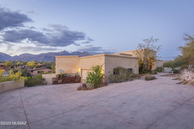 4519 N Camino Kino, Tucson, AZ 85718 - view of side of property featuring a mountain view, stucco siding, a garage, concrete driveway, and fence
