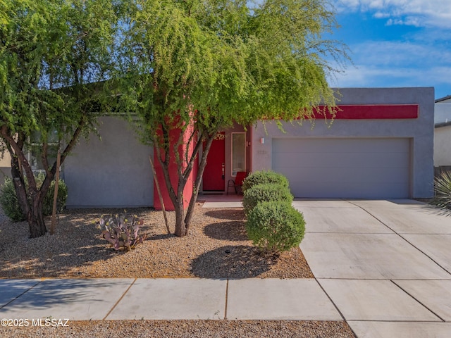 view of front of property featuring a garage, stucco siding, and driveway